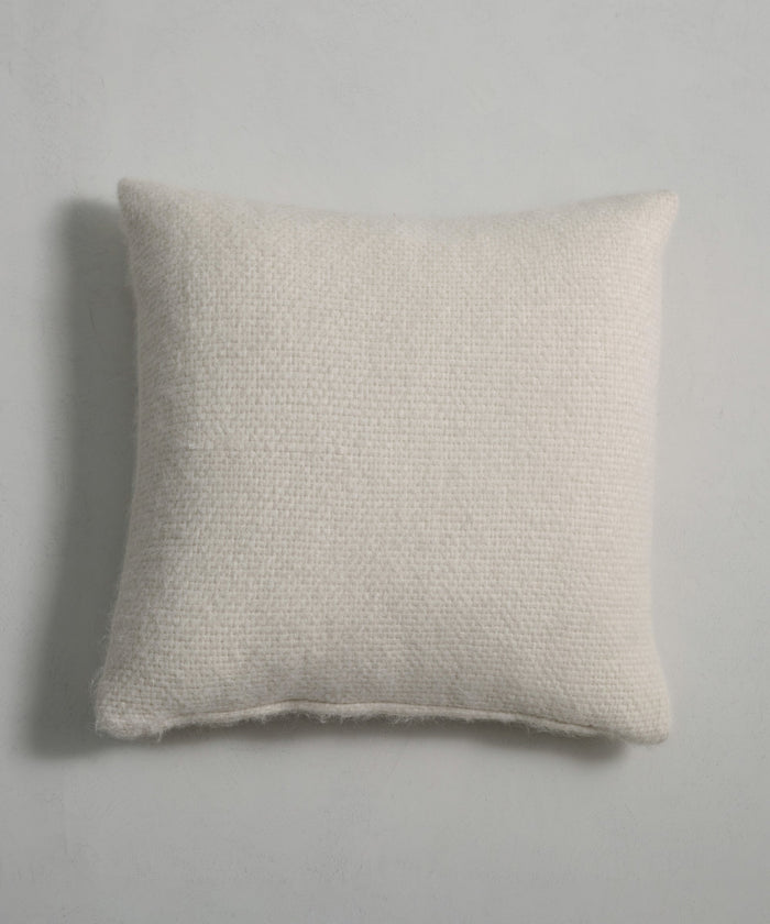 The Alpaca Basketweave Pillow, featuring a rectangular off-white basketweave design and textured surface, rests on a light gray background with a faint shadow cast to the left.