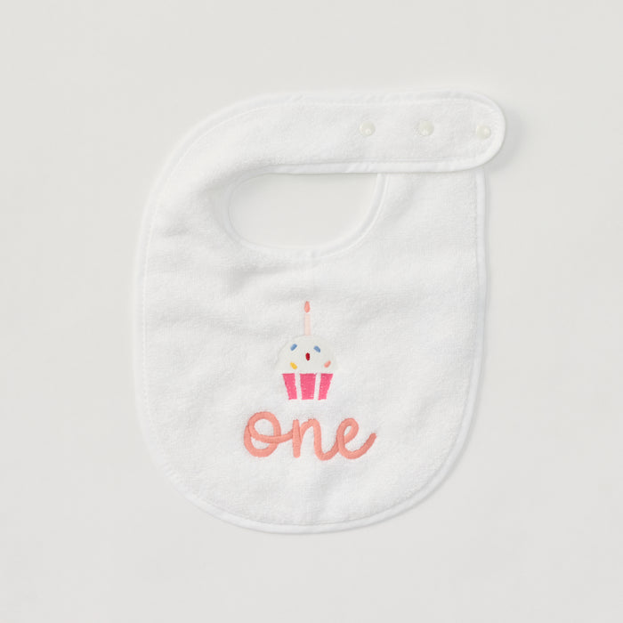 Detail of the embroidered cupcake and 'one' on a white birthday bib.