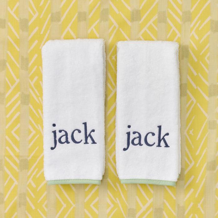 Two white baby burp cloths with matcha green edge piping and blue jack embroidery.