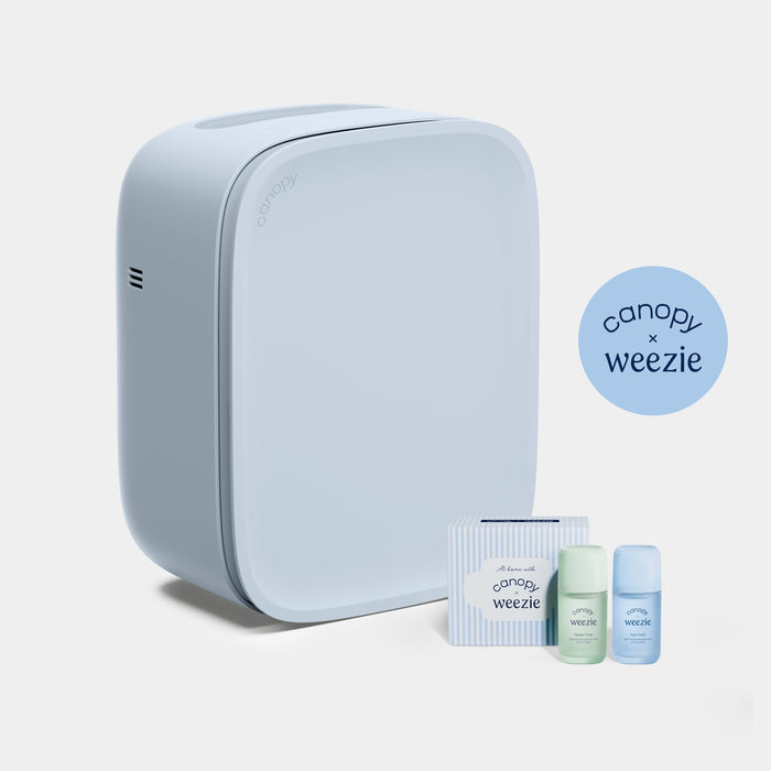 A light blue square-shaped countertop appliance with rounded corners, shown alongside small matching accessory bottles and a box. A circular badge reads 'canopy x weenie'.