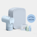 Canopy x Weeze travel kit featuring a light blue travel mask dispenser, a matching square travel case, a striped box, and two small travel bottles on a clean off-white background.