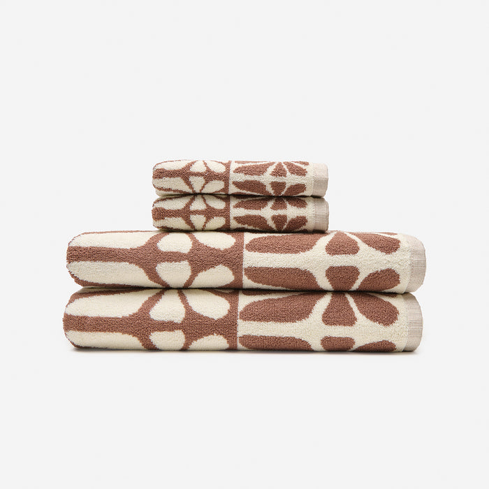 Geometric bath towels, cotton, brown and cream abstract patterns, folded on white background.