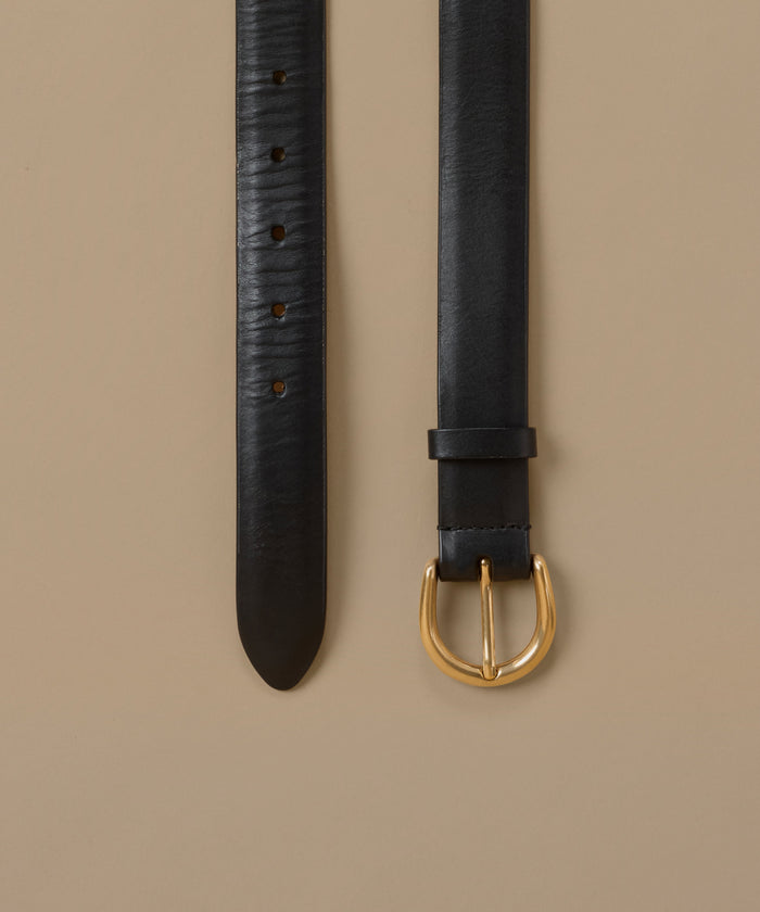 A black leather belt shown in two vertical views against a warm beige background, featuring a polished gold-tone buckle and a textured strap.