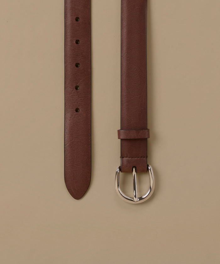 A brown leather belt shown vertically against a solid beige background, displaying both the strap end with holes and the buckle.