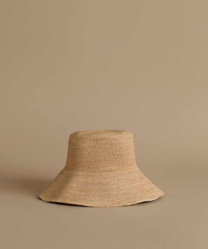 Beige woven hat on a beige background
