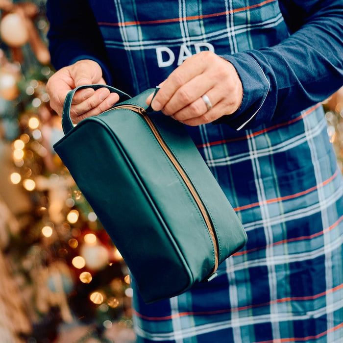 photo of a man in apron, holding the Dopp Kit in Hunter Green