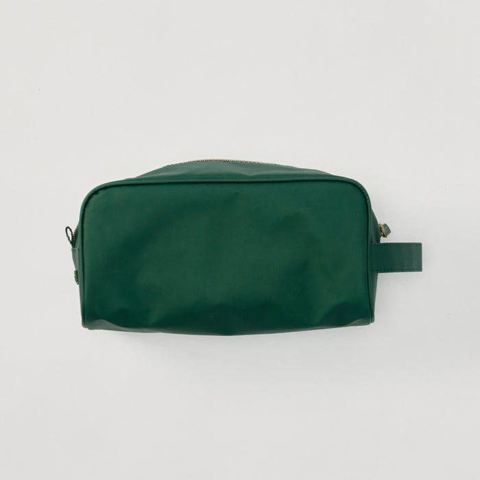 A structured Hunter Green Dopp Kit shown from the side against a clean, neutral background, featuring a durable zipper.