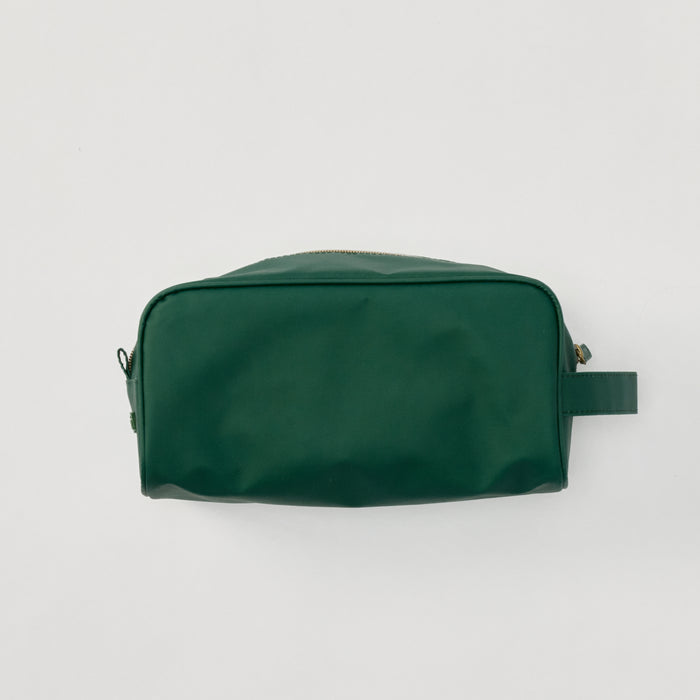 A structured Hunter Green Dopp Kit shown from the side against a clean, neutral background, featuring a durable zipper.