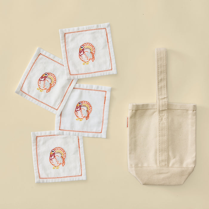 Plain cream canvas wine tote bag with four white turkey embroidered cocktail napkins.