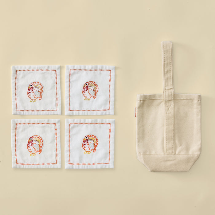 Plain cream canvas wine tote bag with four white turkey embroidered cocktail napkins.