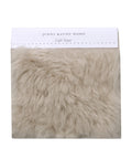 A Fabric Swatch Light Taupe Shearling offers luxurious, faux Icelandic sheep shearling softness in a light taupe hue and complements Jenni Kayne Furniture seamlessly.