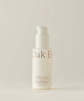 A white pump bottle labeled “Firming Plant Peptide Serum” stands upright against a plain light background; the minimal beige text highlights its powerful plant peptide formula known as a collagen booster.