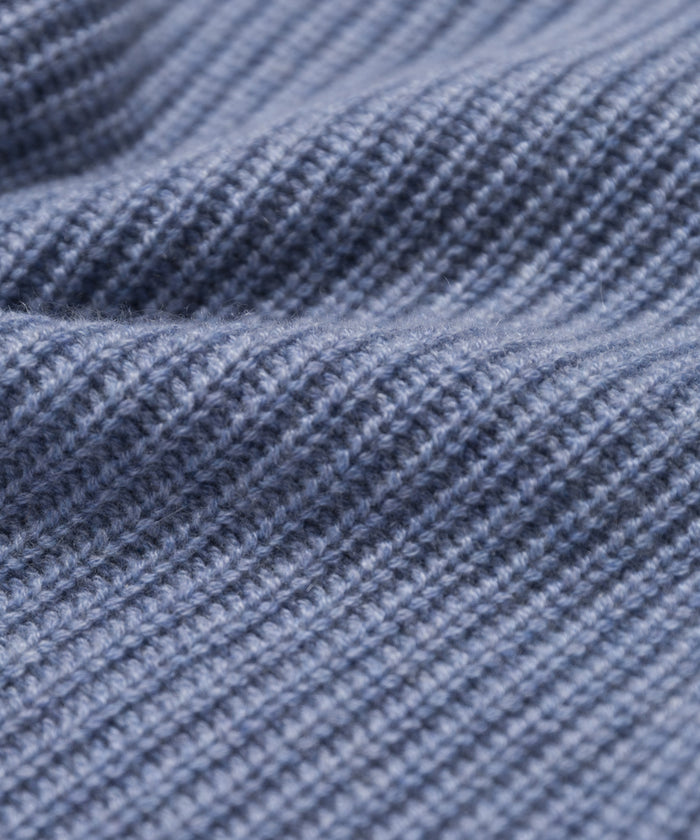 Close-up of soft, blue ribbed fabric with gentle folds, highlighting the fine stitching and cozy quality of the Kids Cashmere Fisherman sweater crafted from luxurious Mongolian cashmere.