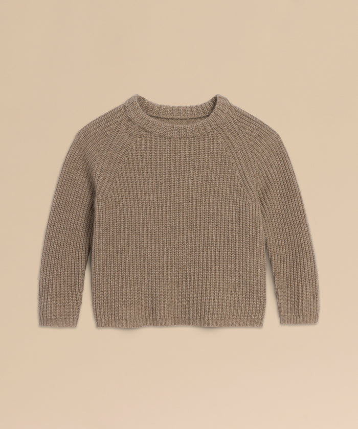 A Kids' Cashmere Fisherman sweater in beige, featuring long sleeves, ribbed knit, and a crew neckline, is laid flat on a light tan background.