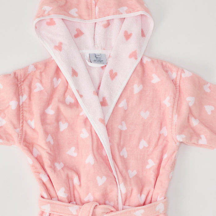 Close-up of a fluffy coral pink bathrobe with white hearts.