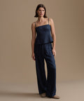 Woman wearing a navy kinney cami and pants against a beige background