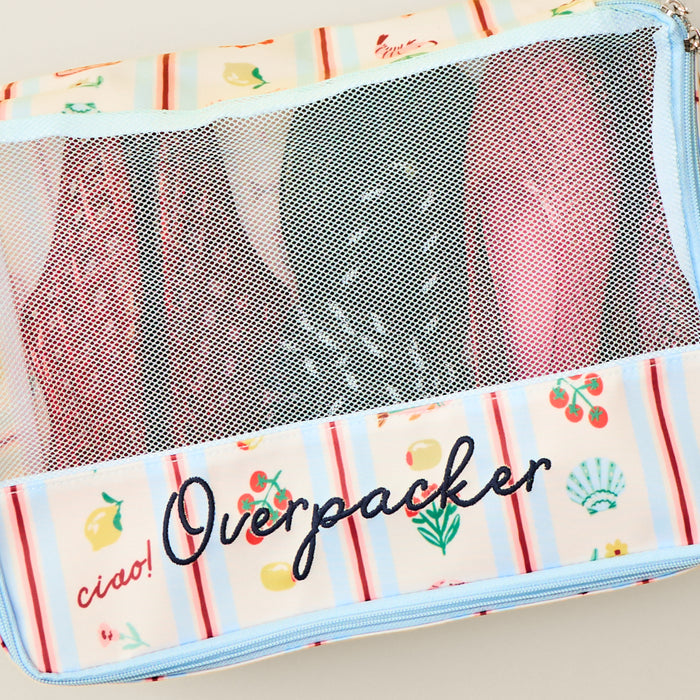 Dolce Vita packing cube with 'Overpacker' embroidery, filled with colorful jelly and rope sandals.