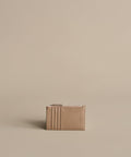A compact Leather Card Holder in taupe with multiple card slots and a top zipper, ideal for light travel. Shown against a plain beige background.