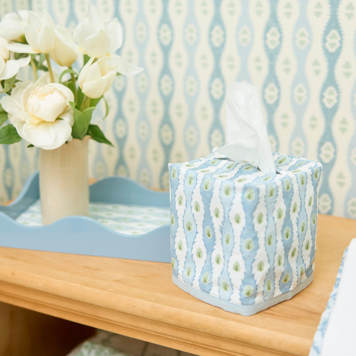 Lee Jofa x Weezie floral Marciana chambray tissue box cover beside a vase of flowers.