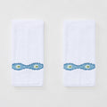 Two white Weezie hand towels with wavy blue Lee Jofa Marciana embroidery on a white background.