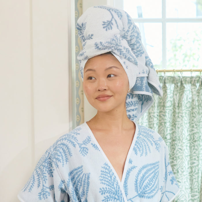 A woman wearing a light blue Palmero patterned robe and a matching towel wrapped on her head