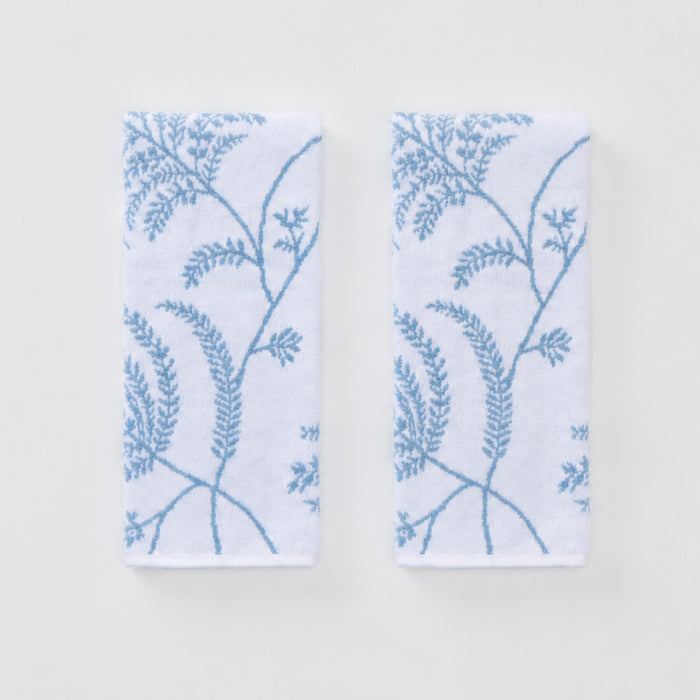 Two white hand towels with a light blue Palmero botanical pattern laid flat side by side.