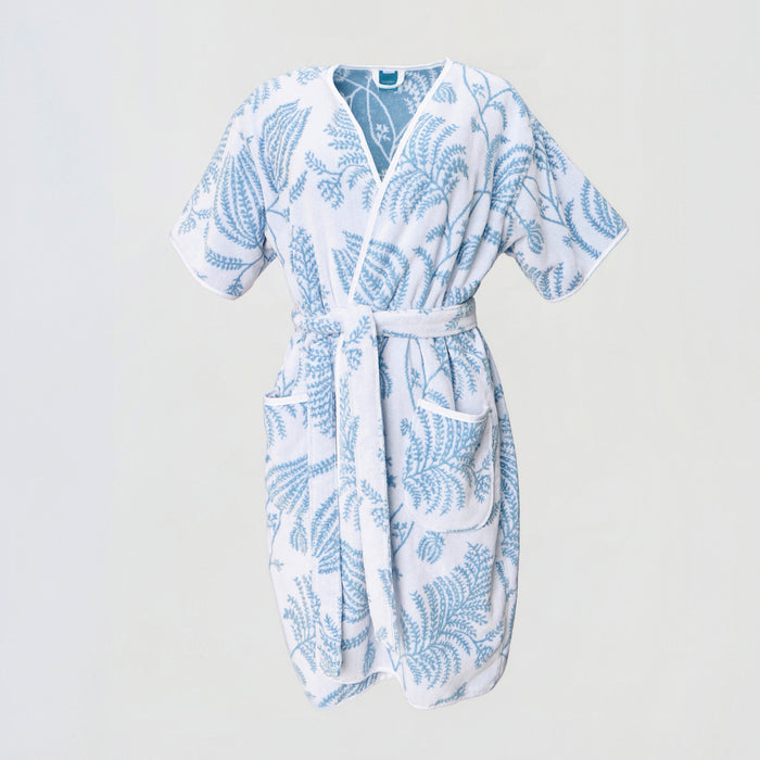 A light blue floral Lee Jofa Palmero short plush robe, tied at the waist with front pockets.