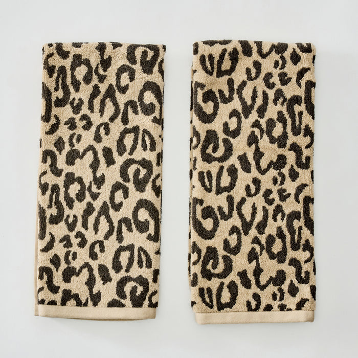 Two rectangular beige towels with a black leopard print pattern and solid beige borders, displayed side-by-side on a light gray background.