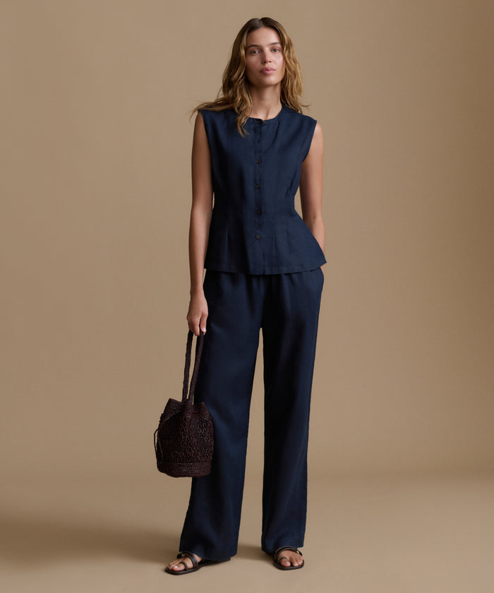 Woman wearing a navy blue outfit with a brown background