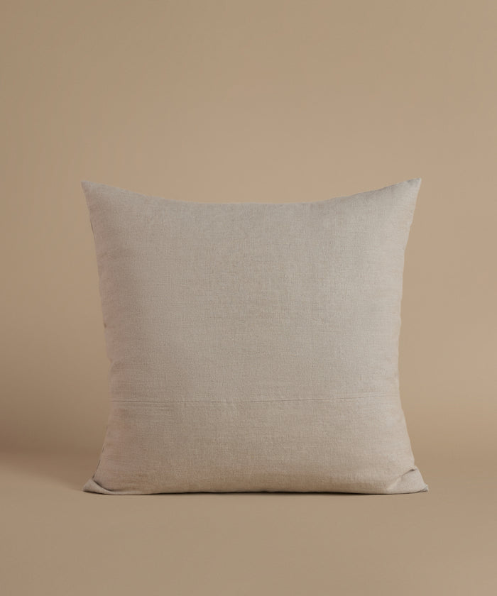 A natural linen pillow against a beige background.