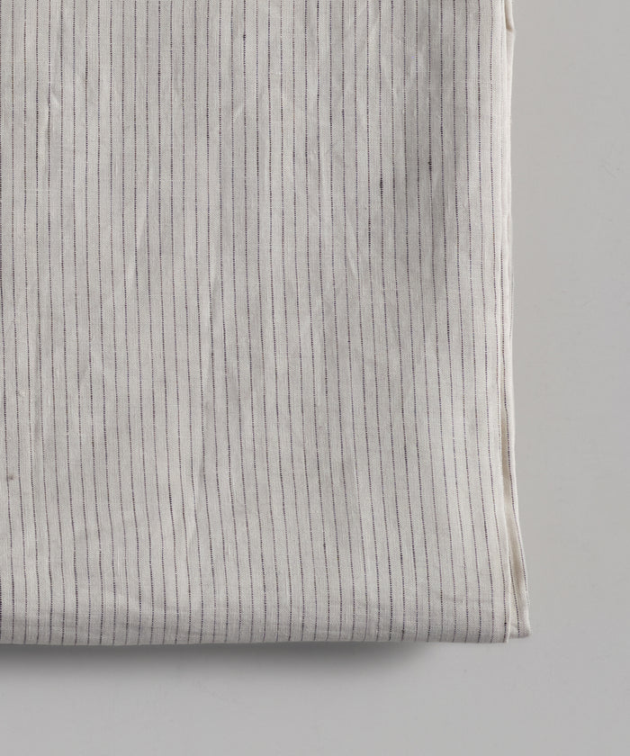 A close-up of the Linen Tablecloth, made in Portugal, shows thin, vertical, evenly spaced black stripes on a plain background.