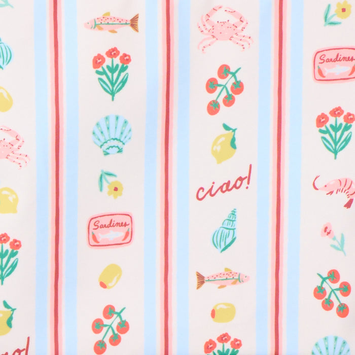 Close-up of the "Dolce Vita" fabric pattern, featuring vertical light blue and pink stripes decorated with small, repeating illustrations of lemons, red tomatoes, flowers, seashells, fish, a shrimp, and a "Sardines" tin. The text "ciao!" is written in red, cursive script among the illustrations.