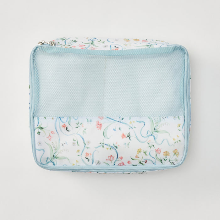 A square zippered travel pouch with a light blue mesh front pocket and a white fabric lower section featuring a delicate multicolor floral and vine pattern, shown on a clean white background.