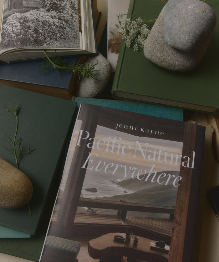 Book titled 'Pacific Natural Everywhere' by Jenni Kayne on a surface with stones and plants.