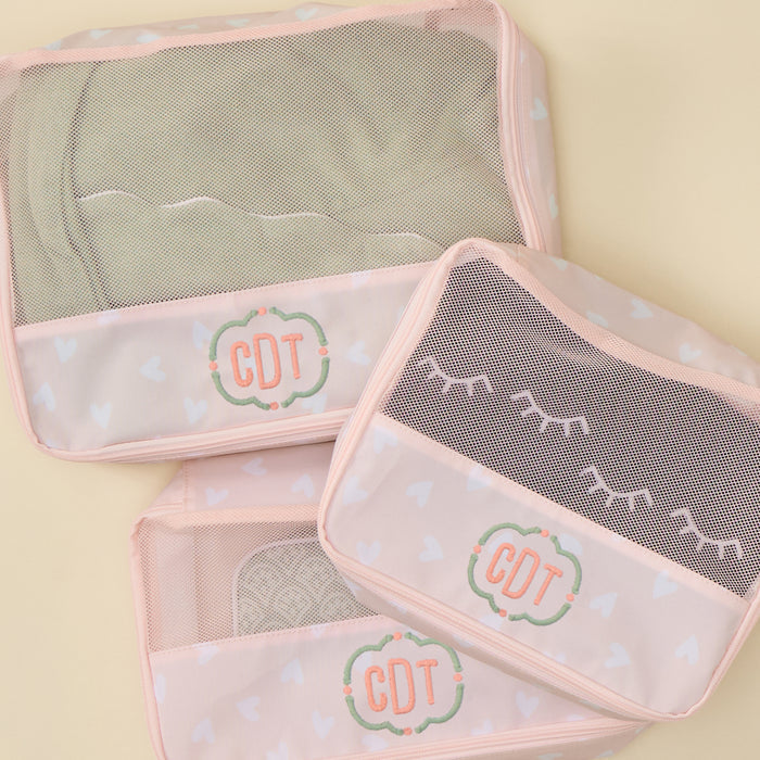 Packing cube bundle in pink heart print featuring lightweight travel organizers with breathable mesh tops.
