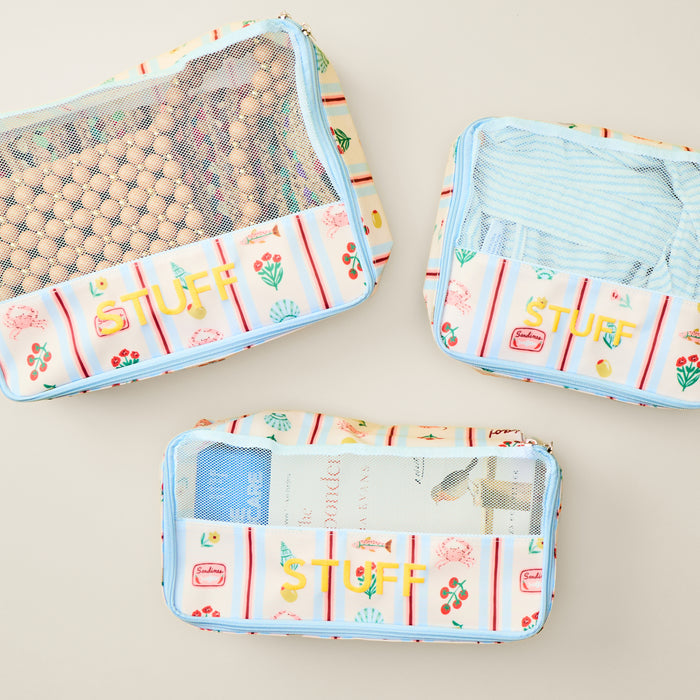 the packing cube bundle in Dolce Vita, with accessories, clothes, and books inside