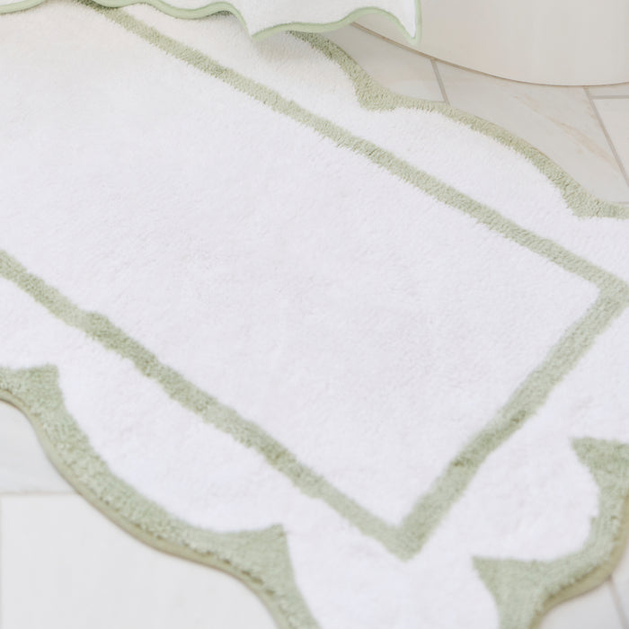 Laurel green scalloped bath runner with crisp white trim on a tiled bathroom floor.