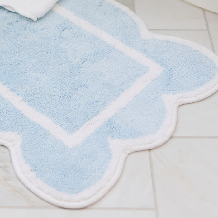 Soft mist blue scalloped bath runner featuring crisp white trim in a bright bathroom