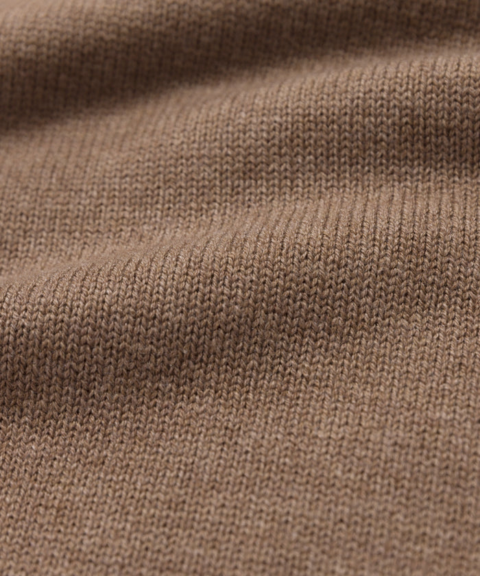 Close-up of the Simone V-Necks brown knitted cotton merino fabric, featuring a visible ribbed texture and gentle folds—showcasing its soft, cozy feel thats perfect for a luxurious layer.