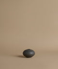 Black ceramic vase on a beige background