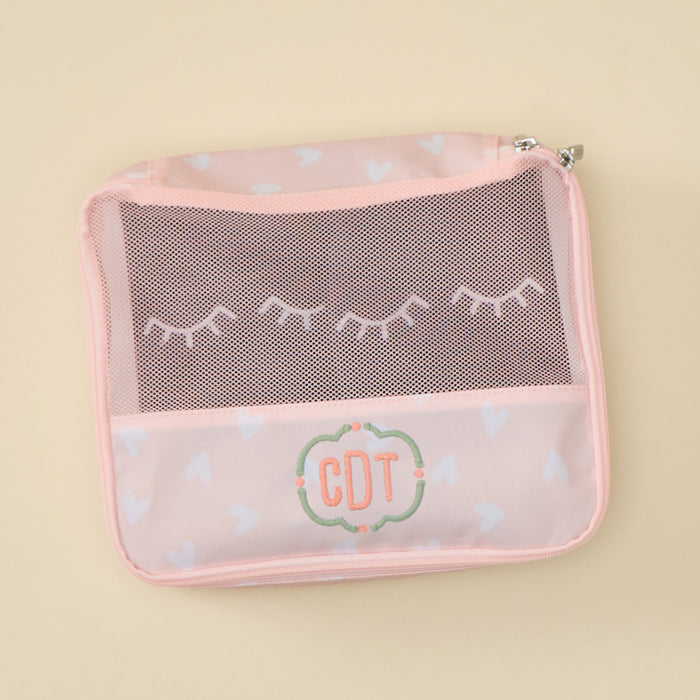 Small packing cube in light pink print with breathable mesh top for organized travel packing.