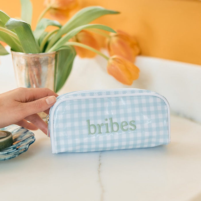 photo of the mini patterned toiletry bag in Light Blue Gingham Archive with embroidery on a bathroom counter