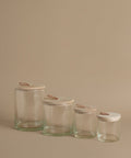 Glass canisters against a beige background.