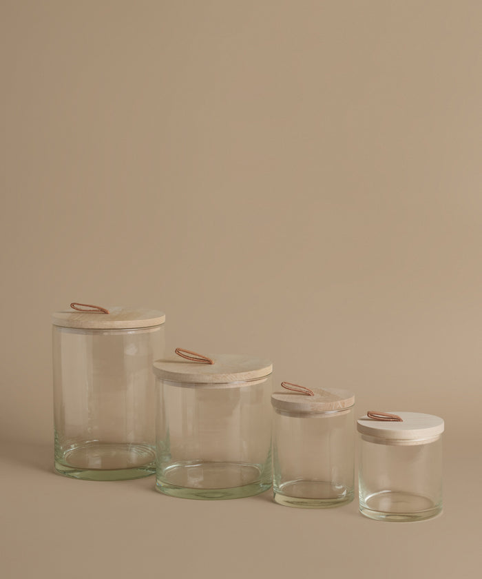 Glass canisters against a beige background.