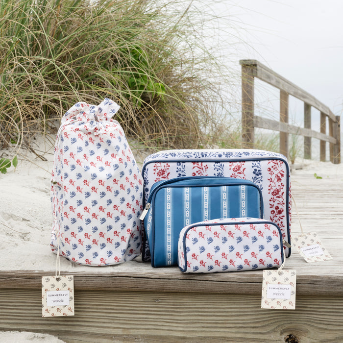 Set of floral and striped bags on a wooden platform with beach background