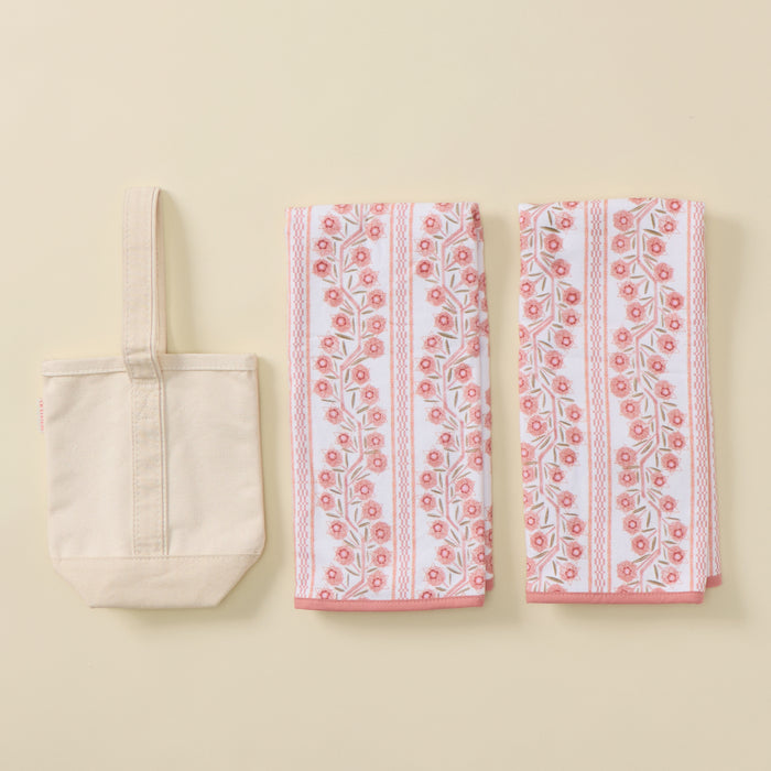 A Hostess Set featuring a plain cream canvas tote bag and two folded towels with a pink and peach floral climbing vine pattern.