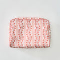 A rectangular toiletry bag featuring a pink and coral floral climbing vine stripe pattern with light pink piping, shown flat against a plain light background.