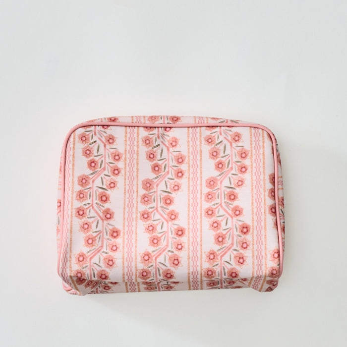 A rectangular toiletry bag featuring a pink and coral floral stripe pattern with light pink piping, shown from the front against a plain light background.