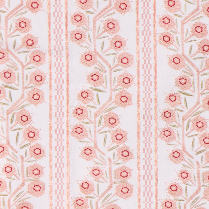 A close-up of a fabric pattern featuring vertical stripes with pink and red floral motifs, green leaves, and geometric checkered details on a white background.