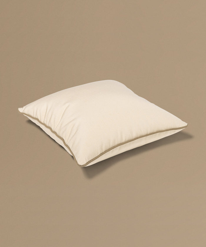 Beige pillow with a tag on a beige background